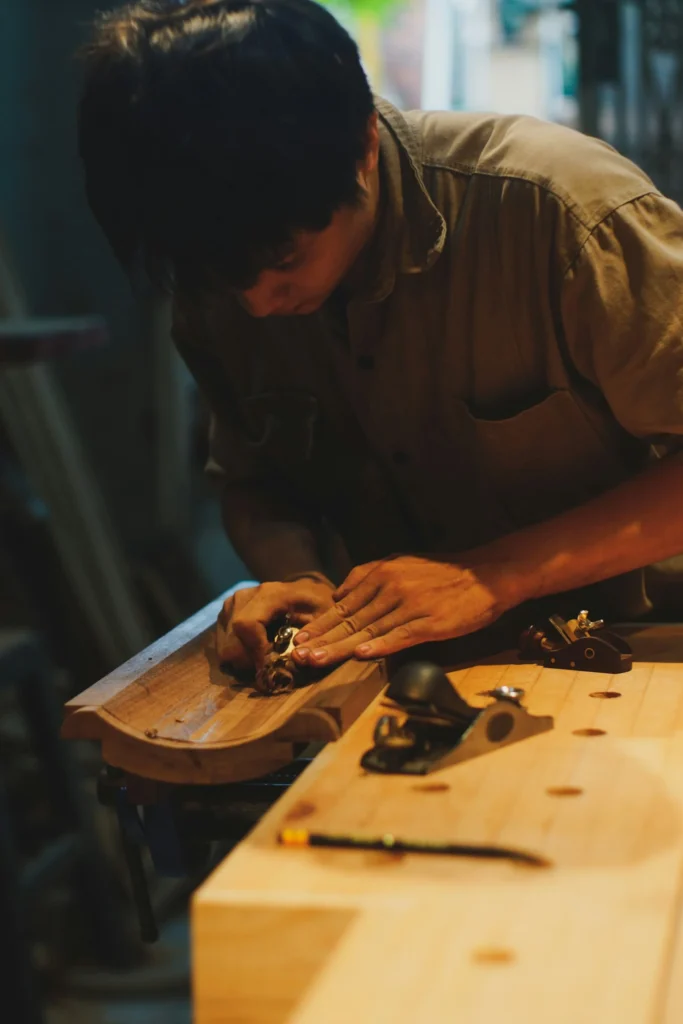 Artigiano che carteggia un pannello di legno