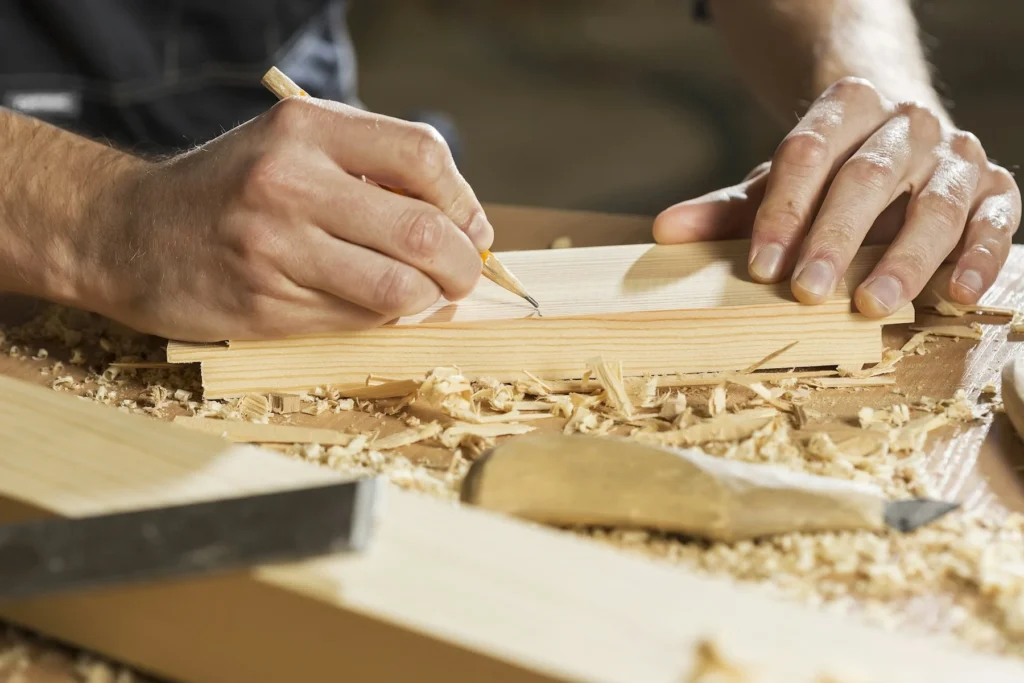 Artigiano che traccia le misure sul legno